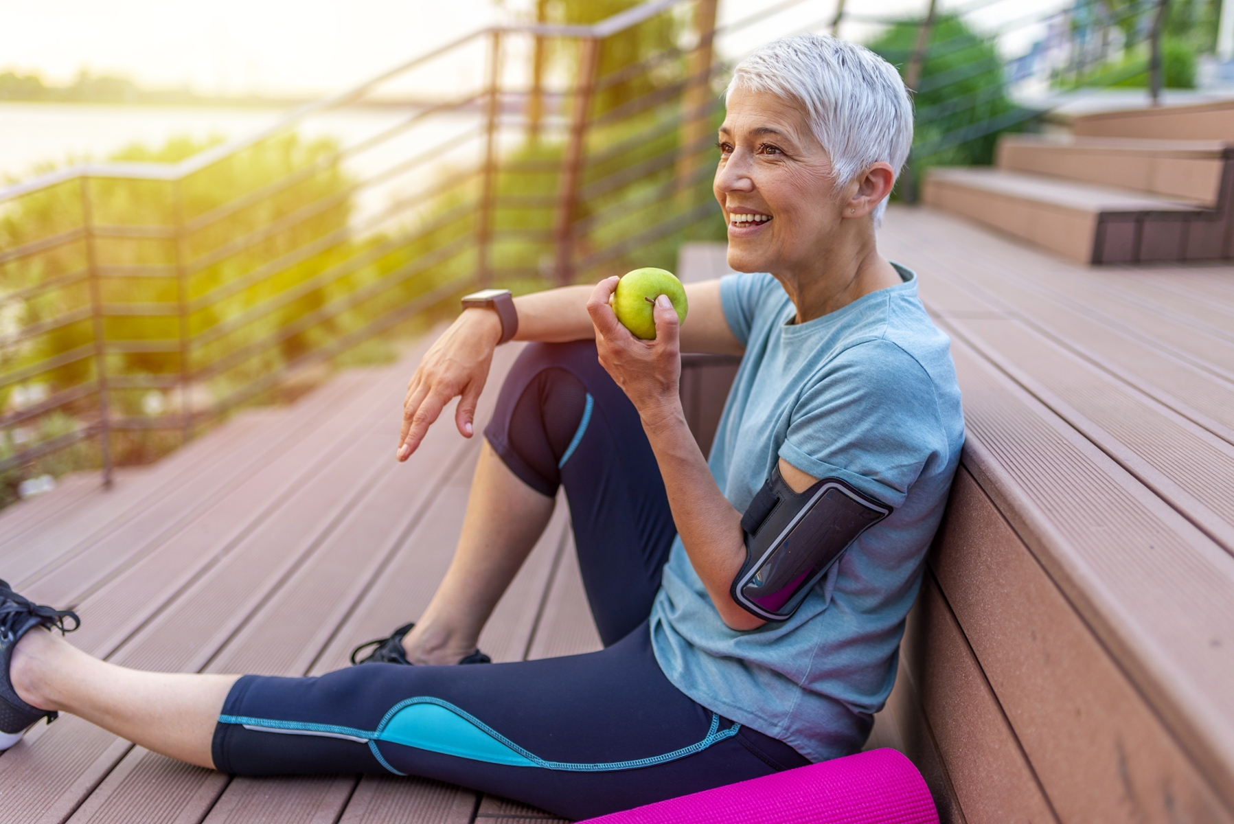 older woman eating green apple with implant supported dentures in mt pleasant sc