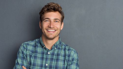 Young man with a bright, confident smile showcasing cosmetic dentistry results