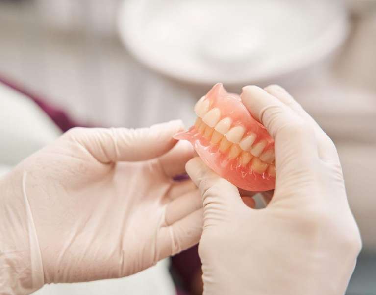 dentist holding full denture set | dentures mt pleasant